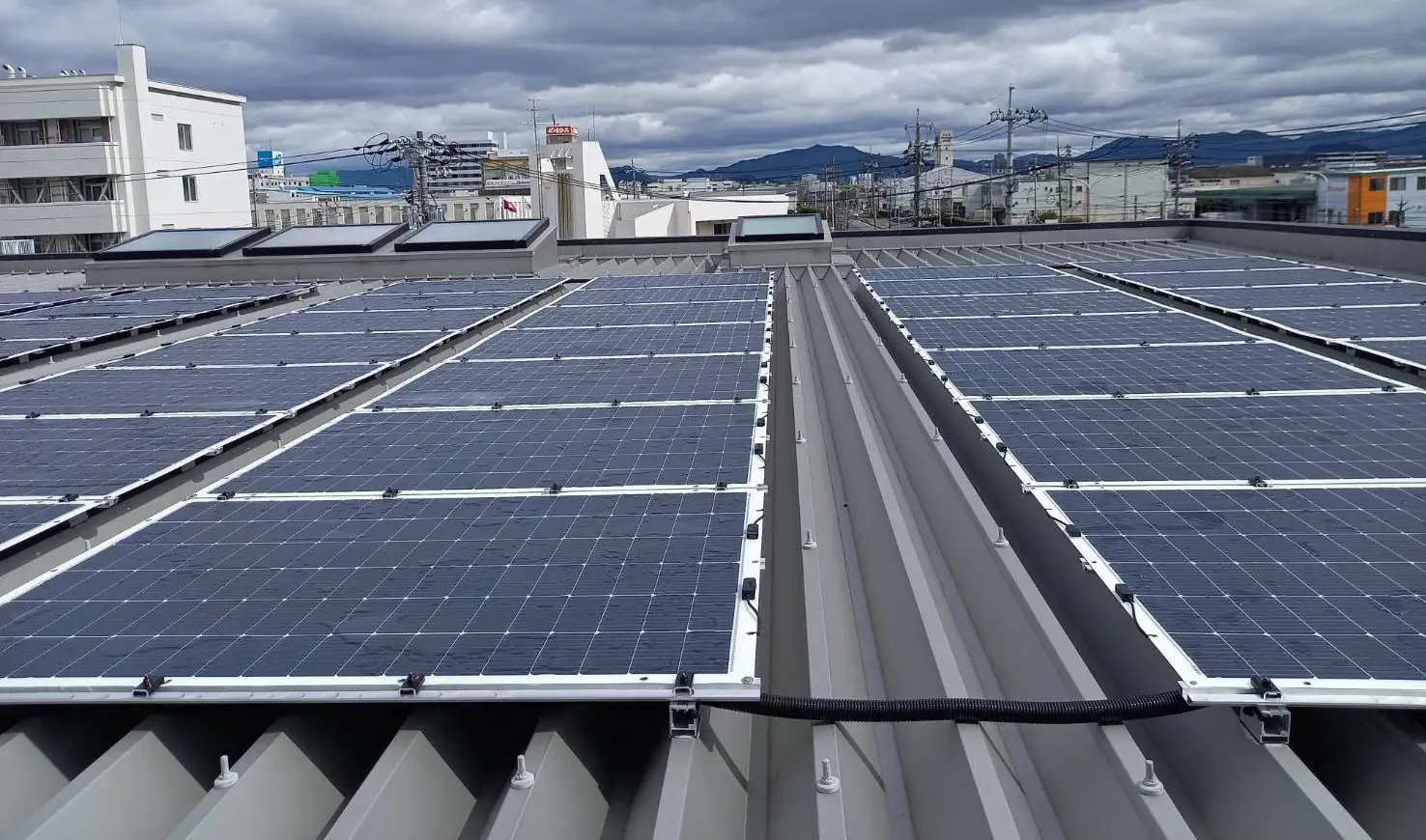 深川医療機本社屋上に設置されたペラペラ太陽光®。広島市の街並みを背景にした実証導入の様子